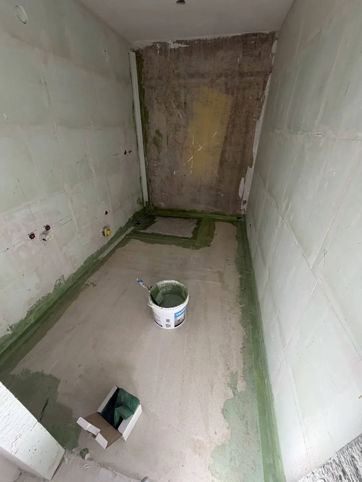 Bandes d'étanchéité posées aux jonctions sol et murs dans une salle de bain