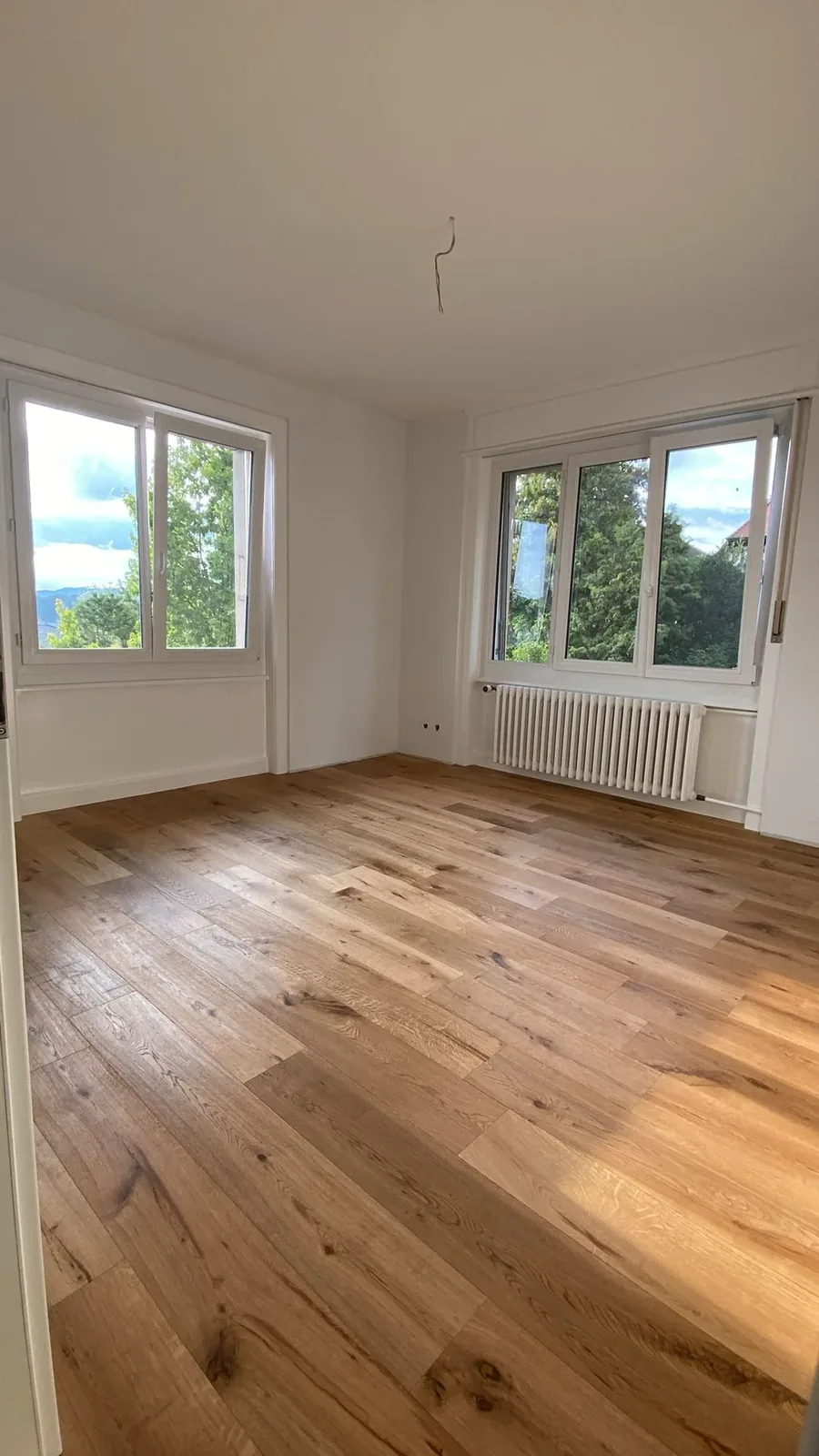 Pièce rénovée avec parquet et peinture